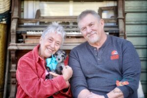 happy older couple with their aussiedoodle puppy